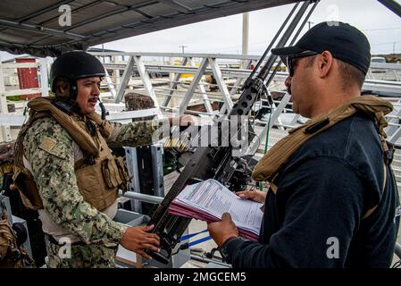 220824-N-NT795-989 SEAL BEACH, KALIFORNIEN (24. August 2022) Quartiermeister 1. Klasse Ruben Varela, Mitglied des Kommando-Trainingsteams, das der Maritime Expeditionary Security Squadron (MSRON) 11, Evaluate Electronics Technician 2. Klasse Alvaro Flores, einem Praktikanten für taktische Handwerksingenieure, zugewiesen ist. Zu den Kenntnissen über Waffen, die seine Crew im Rahmen der täglichen voroperativen Überprüfung im Rahmen des Vorbereitungskurses der Maritime Expeditionary Security Force (MESF) Boat University (BU) erworben hat. Die MESF BU soll Seeleute ausbilden und qualifizieren, um die Mobilisierungsbereitschaft aufrechtzuerhalten. MESF ist eine Kernfunktion der Marine, die Port bereitstellt Stockfoto