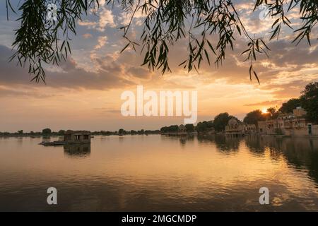 Schöner Sonnenuntergang am Gadisar Lake, Jaisalmer, Rajasthan, Indien. Untergehende Sonne und bunte Wolken am Himmel mit Blick auf den Gadisar See. Stockfoto