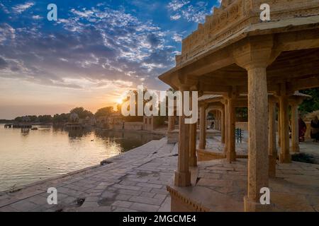 Schöner Sonnenuntergang am Gadisar Lake, Jaisalmer, Rajasthan, Indien. Untergehende Sonne und bunte Wolken am Himmel mit Blick auf den Gadisar See. Stockfoto