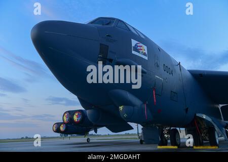 Die Sonne geht über einer B-52H Stratofortress auf, die am 23. August 2022 auf der Minot Air Force Base in North Dakota geparkt ist. Die B-52H Stratofortress ist ein schwerer Bomber, der eine Vielzahl strategischer Missionen durchführen kann. Luftwaffe, B-52H Stratofortress, Sonnenaufgang, Fluglinie, Minotafb, Stockfoto