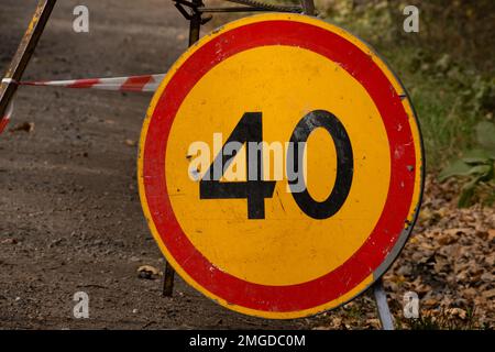 Geschwindigkeitsbegrenzungsschild aufgrund von Straßenarbeiten mit einer Höchstgeschwindigkeit von 40 km/h. Kreisverkehrsschild am Boden. Stockfoto