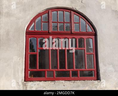 Ein altes altmodisches Holzfenster mit abblätternder Farbe und Rahmen müssten repariert oder ersetzt werden. Stockfoto