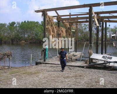 Nachwirkungen - Verschiedenes - 26-HK-46-1. Coastie mit zerstörtem Trockendock. Hurrikan Katrina Stockfoto