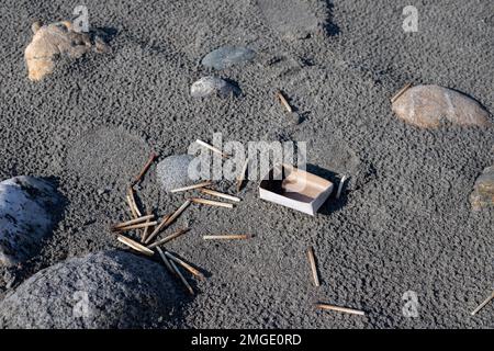 Streichhölzer mit verbrannten Streichhölzern am Flussufer Stockfoto