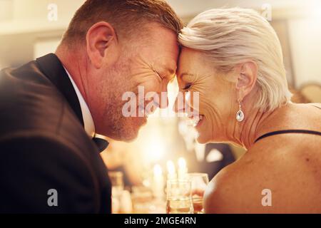 Liebe, Stirn oder Seniorenpaar auf einer Party zum Feiern von Toren oder Neujahr bei einer luxuriösen gesellschaftlichen Veranstaltung. Romantik, glückliche Frau oder romantischer Mann lächelt Stockfoto
