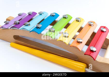 Regenbogenfarbenes Holzxylophon auf weißem Hintergrund. Kinderspielzeug, Kreativität, Gehirnentwicklung, innovatives Konzept. Stockfoto
