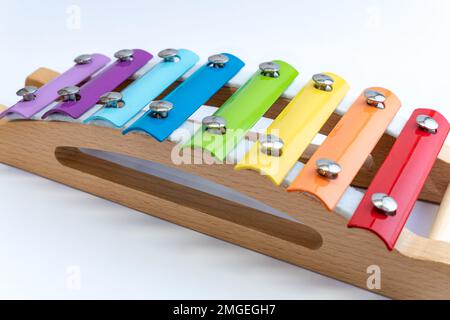 Regenbogenfarbenes Holzxylophon auf weißem Hintergrund. Kinderspielzeug, Kreativität, Gehirnentwicklung, innovatives Konzept. Stockfoto