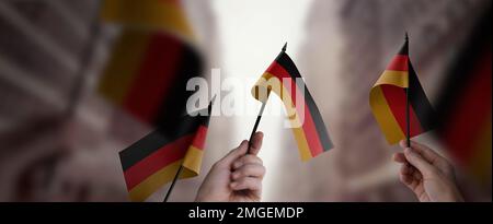 Eine Gruppe von Menschen, die kleine Flaggen Deutschlands in der Hand halten. Stockfoto