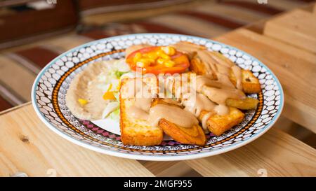 Afrikanische Kombi-Platte mit Reis, gebratenem Käse, gegrilltem Gemüse, Erdnusssoße und anderen traditionellen Produkten. Stockfoto