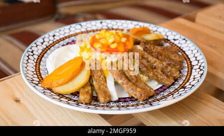 Afrikanische Kombi-Platte mit Reis, gebratenem Käse, gegrilltem Gemüse, Erdnusssoße und anderen traditionellen Produkten. Stockfoto