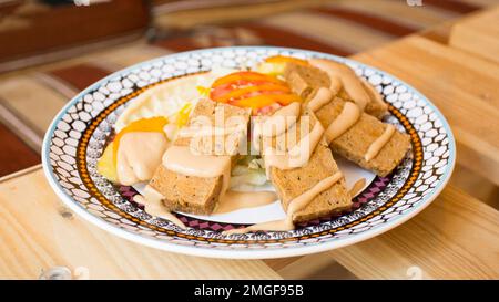 Afrikanische Kombi-Platte mit Reis, gebratenem Käse, gegrilltem Gemüse, Erdnusssoße und anderen traditionellen Produkten. Stockfoto