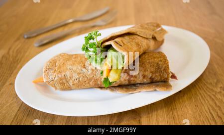 Goraasa-Brötchen mit Gemüse. Goraasa ist ein sudanesischer Pfannkuchen oder Fladenbrot, der flauschig, vielseitig, weich und dünn ist. Stockfoto