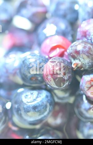 Blaubeeren, Hintergrund mit Beeren, Draufsicht. Unscharfer Blaubeerhintergrund. Struktur aus Heidelbeeren, flaches Design. Vertikales Makrobild. Stockfoto