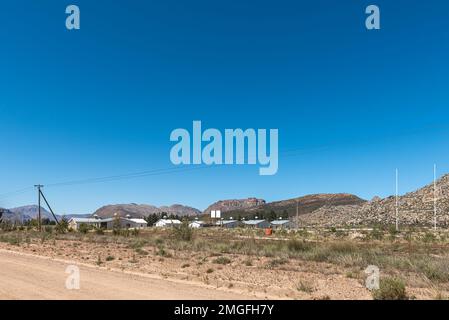 KOUE BOKKEVELD, SÜDAFRIKA - 9. Sep. 2022: Landarbeiterhäuser und Rugby-Feld auf der Straße R303 in der Region Koue Bokkeveld der Provinz Westkap Stockfoto