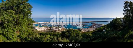 Panoramablick aus der Vogelperspektive auf den Yachthafen der kleinen Stadt Capo d'Orlando, wo zahlreiche Segelboote vor Anker liegen. Stockfoto