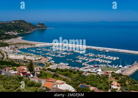 Luftaufnahme des Yachthafens der kleinen Stadt Capo d'Orlando, wo zahlreiche Segelboote vor Anker liegen. Stockfoto