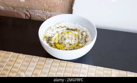 Hummus ist eine mit Zitronensaft gekochte Kichererbsencreme, einschließlich Tahinipaste und Olivenöl, die je nach lokaler Variante auch eingerechnet werden kann Stockfoto