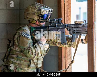 Ein Soldat aus dem 3. Zug, Blackhorse Company, 2-3. Infanterie-Regiment, 1-2. Stryker Brigade-Kampfteam trägt eine verbesserte integrierte visuelle Augmentation System-Schutzbrille, während er während einer städtischen Razzia von Bewegung zu Kontakt auf der Joint Base Lewis-McChord, Washington, 24. August 2022 an der Sicherheitskontrolle zieht. Die Übung war Teil einer zweitägigen Demonstrationsveranstaltung, die vom Program Executive Office of Ground Combat Systems veranstaltet wurde, um das Feedback der Soldaten in die Entwicklung neuer militärischer Kampftechnologien zu integrieren. Stockfoto