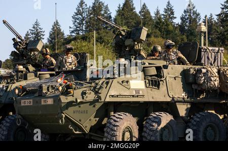 Soldaten aus dem 3. Zug, Blackhorse Company, 2-3. Infanterie-Regiment, 1-2. Stryker Brigade-Kampfteam tragen eine verbesserte integrierte visuelle Augmentation System-Brille, während sie auf den gepanzerten Stryker-Fahrzeugen sitzen und sich auf eine städtische Razzia auf der Joint Base Lewis-McChord, Washington, vorbereiten, 24. August 2022. Die Übung war Teil einer zweitägigen Demonstrationsveranstaltung, die vom Program Executive Office of Ground Combat Systems veranstaltet wurde, um das Feedback der Soldaten in die Entwicklung neuer militärischer Kampftechnologien zu integrieren. Stockfoto