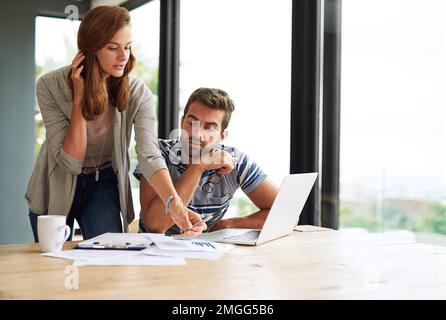 Über das Budget gehen. Ein junges Paar, das an seinem Haushaltsbudget arbeitet und Rechnungen online bezahlt. Stockfoto