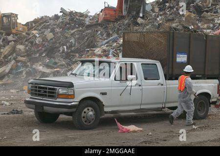 Nachwirkungen - Trümmer - 26-HK-31-3. Lakeview-Trümmer in LA, Nahaufnahme eines Lastwagens, der von zwei Kranen auf einem Trümmerhaufen gefüllt wird. Hurrikan Katrina Stockfoto