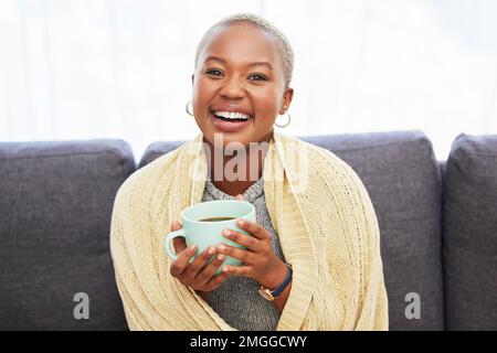 Schwarze Frau, Porträt und Sofa mit Kaffee, Lächeln oder Entspannen im Wohnzimmer für meine Zeit. Junge afrikanische Dame, trinken oder Tee auf der Couch, um glücklich zu sein Stockfoto