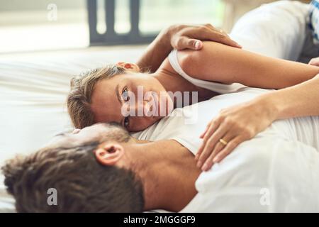 Liebe ist es immer wert, im Haus zu bleiben. Ein glückliches junges Paar, das sich zu Hause im Bett entspannt. Stockfoto