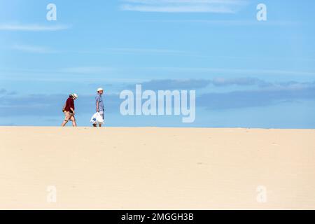 Ein Paar überquert das Dünenfeld von Corralejo, um zum Strand zu gelangen. Fuerteventura, Kanarische Inseln. Stockfoto