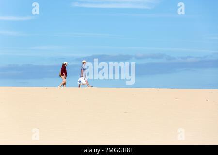 Ein Paar überquert das Dünenfeld von Corralejo, um zum Strand zu gelangen. Fuerteventura, Kanarische Inseln. Stockfoto