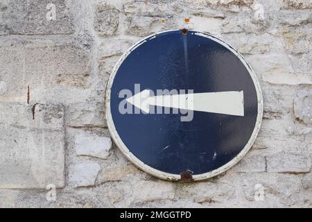 Ein altes Straßenschild auf der Straße weist darauf hin, dass das Auto rechts abbiegen muss Stockfoto