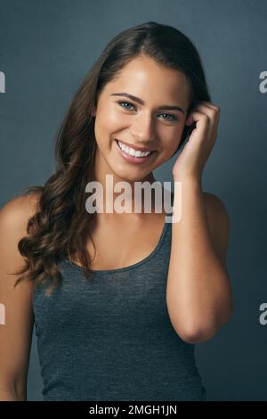 Natürlich schön. Studiofoto einer schönen jungen Frau vor blauem Hintergrund. Stockfoto