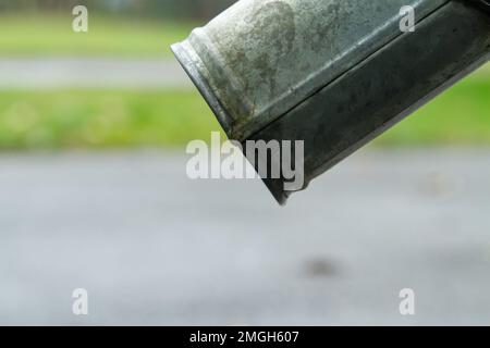 Nahaufnahme von Abflussrohren und Asphalt-Gehweg. Unterseite des Auswurfkrümmers. Stockfoto