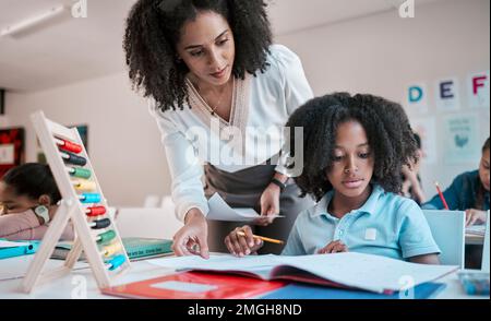 Mathematik, Bildung oder Lehrer, die einem Kind in einem Klassenzimmer bei der Entwicklung, Entwicklung oder dem Studium helfen. Schreiben, Notizbuch oder schwarze Frau unterrichten Stockfoto