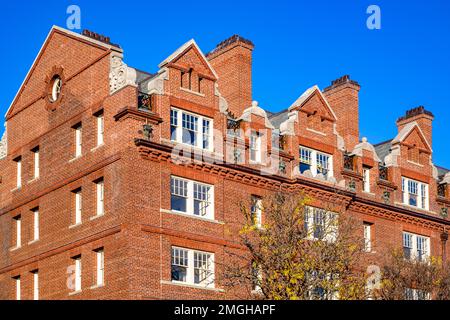 Ein klassisches, mehrstöckiges Apartment aus rotem Backstein in strikter geometrischer Form mit Wohnräumen auf dem Dachboden und geschmiedeten Balkonen im Cambr Stockfoto