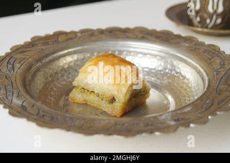 Baklava ist ein aus Pistazien oder zerdrückten Walnüssen hergestellter Kuchen, der in einem Phyllo-Teig verteilt und in Sirup oder Honigsirup gebadet wird. Stockfoto