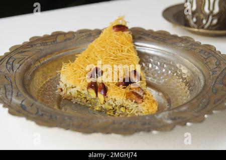 Baklava ist ein aus Pistazien oder zerdrückten Walnüssen hergestellter Kuchen, der in einem Phyllo-Teig verteilt und in Sirup oder Honigsirup gebadet wird. Stockfoto