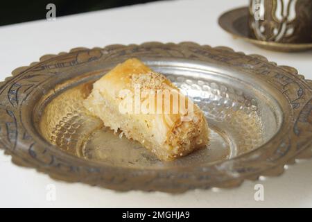 Baklava ist ein aus Pistazien oder zerdrückten Walnüssen hergestellter Kuchen, der in einem Phyllo-Teig verteilt und in Sirup oder Honigsirup gebadet wird. Stockfoto