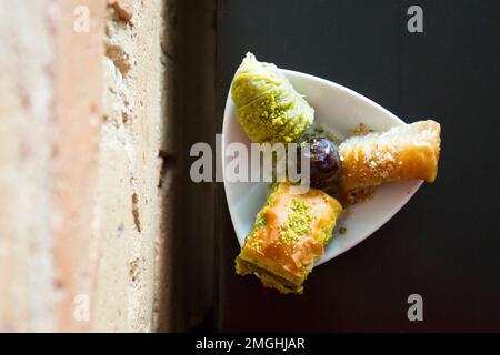 Baklava ist ein aus Pistazien oder zerdrückten Walnüssen hergestellter Kuchen, der in einem Phyllo-Teig verteilt und in Sirup oder Honigsirup gebadet wird. Stockfoto