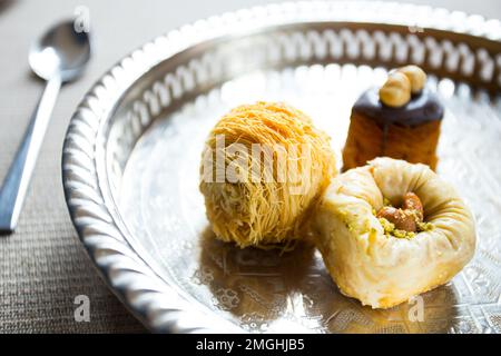 Baklava ist ein aus Pistazien oder zerdrückten Walnüssen hergestellter Kuchen, der in einem Phyllo-Teig verteilt und in Sirup oder Honigsirup gebadet wird. Stockfoto