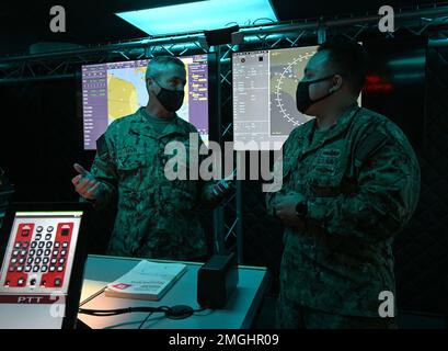 GROSSE SEEN, Illinois (24. August 2022) Rear ADM. Pete Garvin, Commander, Naval Education and Training Command, Left, spricht über den Virtual Operator Trainer (VOT) mit Operations Specialist 2. Class Gianmarco Delgado Flores, einem Ausbilder für Operations Specialist „A“ School, Surface Combat Systems Training Command Great Lakes, in Great Lakes, Illinois, 24. August 2022. Das VOT ist ein computerbasiertes System, das das Situationsbewusstsein von Wachposten auf der Brücke und im Kampfinformationszentrum erhöht und alles zusammenführt, was die Schüler während ihres Trainings gelernt haben Stockfoto