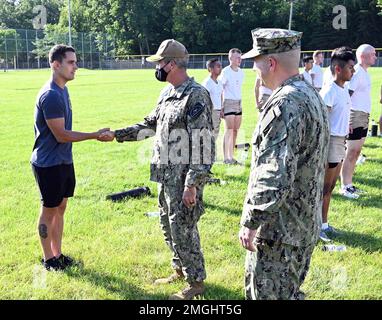 GROSSE SEEN, Illinois (24. August 2022) Rear ADM. Pete Garvin, Center, Commander, Naval Education and Training Command, überreicht eine Münze an Navy Diver 1. Class Marcus Yensick, der dem Center for Explosive Ordnance Disposal and Diving (CEODD) zugeteilt wurde, für seine Wahl zum CEODD's Sailor of the Year in Great Lakes, Illinois, 24. August 2022. Auf der Lernseite werden zwei Kurse für Kandidaten für die Sprengstoffbeseitigung (EOD), Navy Diver (ND) und Diving Medical Technician (DMT) angeboten. Der 18-tägige Vorbereitungskurs soll Seeleute auf die EOD- und ND-A-Schulen vorbereiten, indem er Schulungen und ME anbietet Stockfoto