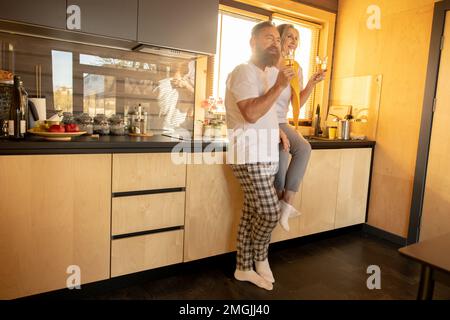 Ein verheiratetes Paar, das sich bei einem Glas Wein amüsiert und glücklich aussah Stockfoto