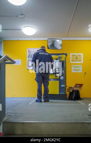 Ein Techniker repariert eine Zahlstelle in einer Parkgarage Stockfoto