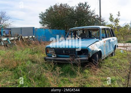 Auf Dem Land. Zerstörte zivile Autos stehen am Straßenrand. Krieg in der Ukraine. Russische Invasion der Ukraine. Kriegsverbrechen Stockfoto