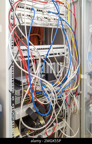 Im Server-Rack sind viele verschiedene farbige Netzwerkkabel mit den Netzwerk-Switches verbunden Stockfoto