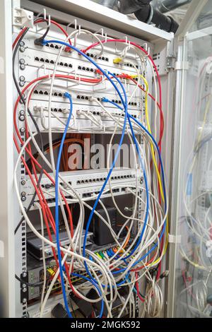 Im Server-Rack sind viele verschiedene farbige Netzwerkkabel mit den Netzwerk-Switches verbunden Stockfoto