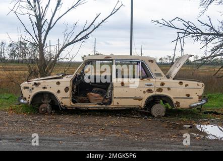 Auf Dem Land. Zerstörte zivile Autos stehen am Straßenrand. Krieg in der Ukraine. Russische Invasion der Ukraine. Kriegsverbrechen Stockfoto