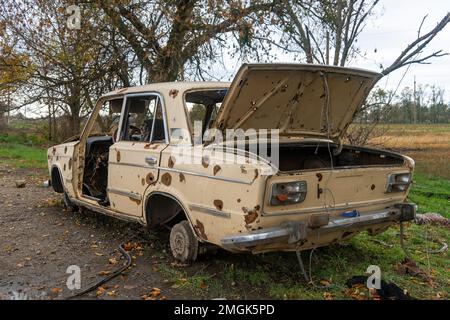 Auf Dem Land. Zerstörte zivile Autos stehen am Straßenrand. Krieg in der Ukraine. Russische Invasion der Ukraine. Kriegsverbrechen Stockfoto