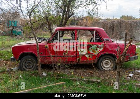 Auf Dem Land. Zerstörte zivile Autos stehen am Straßenrand. Krieg in der Ukraine. Russische Invasion der Ukraine. Kriegsverbrechen Stockfoto