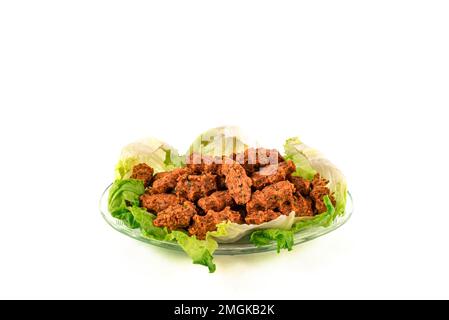 Schließen Sie türkische vegane Linsenbällchen mit Salat auf einer Glasplatte. Vegetarische Gerichte, traditionelle türkische Linsenbällchen. Mercimek koftesi. Stockfoto